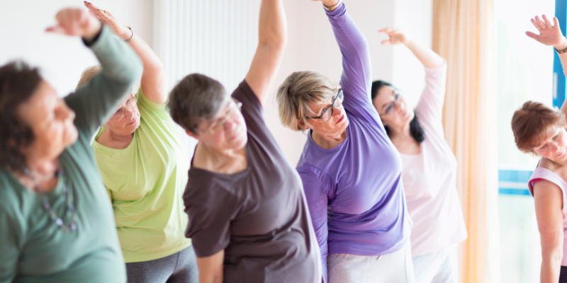 Group of older adults in a yoga class Group of older adults in a yoga class