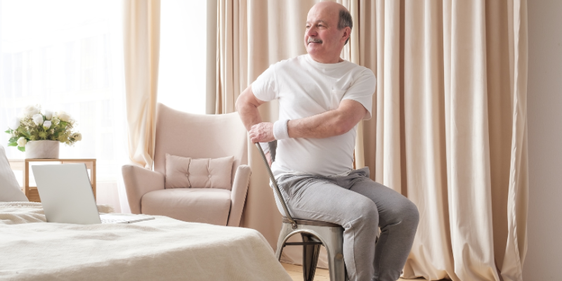 Senior man doing chair yoga