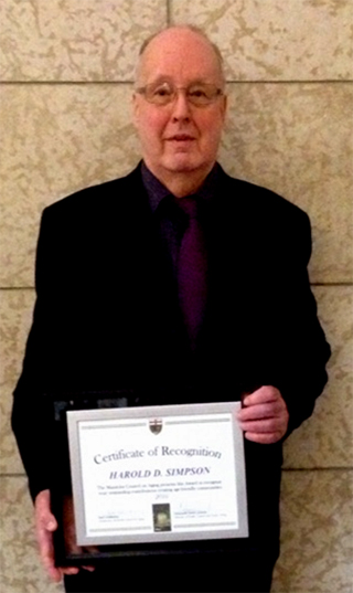 dave-simpson Lifeline volunteer Dave, holding his certificate of recognition from the Manitoba government.