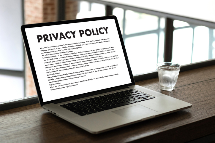 Computer laptop on a desk with Privacy Policy written across the screen.