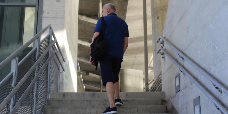Older man walking up the stairs for exercise