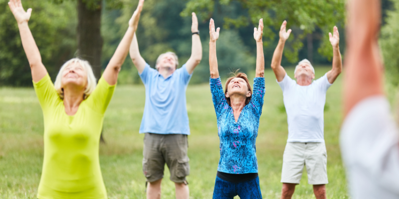 Group of older adults doing yoga outdoors